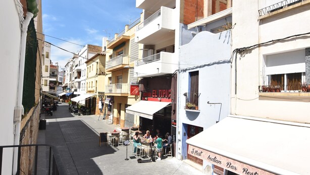 A narrow street with outdoor seating at a restaurant. - Charming town house in the center of Roses, Costa Brava! Two rooms, 200 meters from the beach. Modern kitchen and balcony with sea views. (Roses)