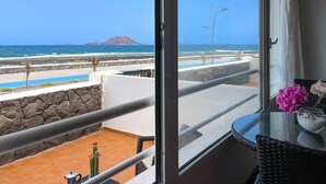 Ein Balkon mit Blick auf das Meer und ein Berg.