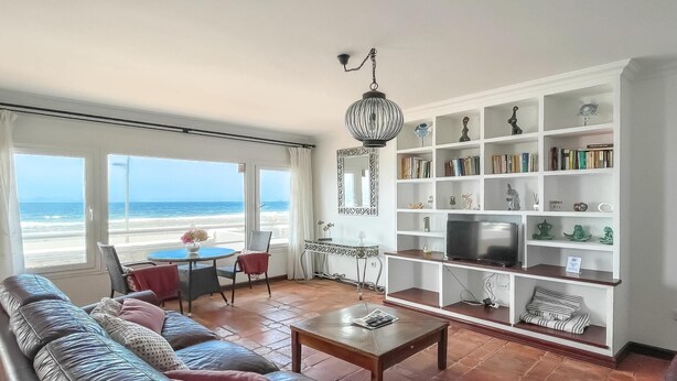 Ein Wohnzimmer mit einer Couch, einem Couchtisch, einem Fernseher und einem Bücherregal.