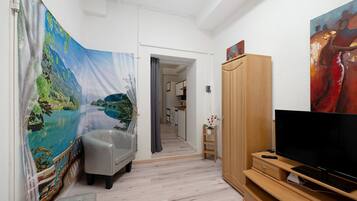A hallway with a sofa, a TV, and a cabinet.