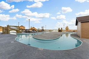 A swimming pool with a wooden bridge, lounge chairs, and a covered area. - Panoramic Lake&Mtn View, Private HotTub & Firepit! (Kimberling City)