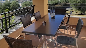 Un balcon avec une table et des chaises, donnant sur un paysage magnifique.