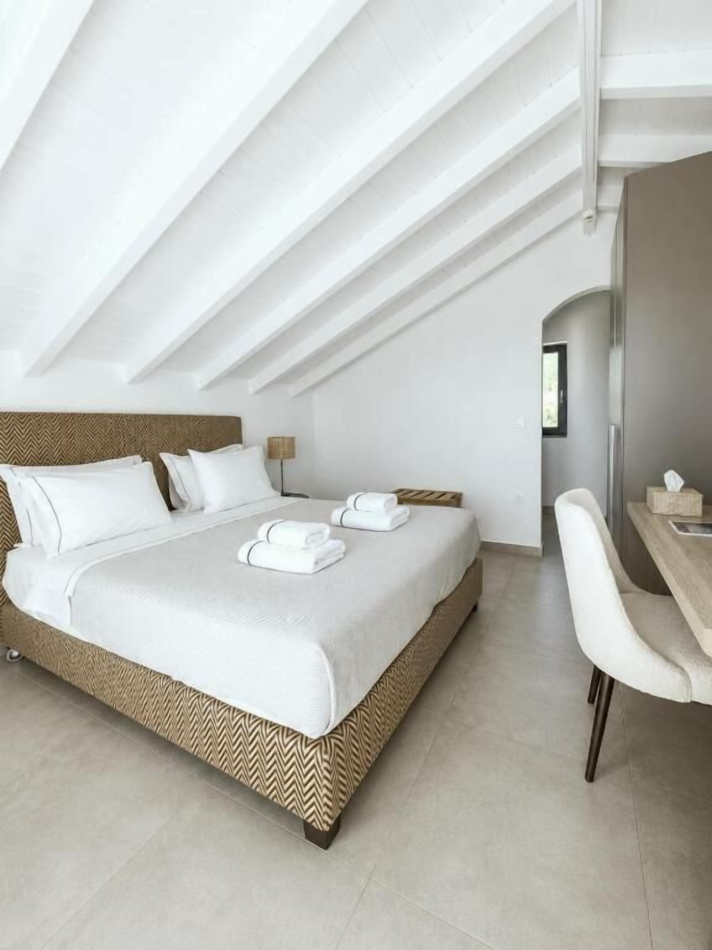 Een moderne hotelkamer met een groot bed, een bureau en een stoel.