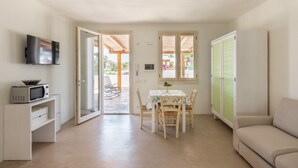 A compact living space with a kitchenette, a dining area, and a sofa. - Cava Li Santi Residence - Appartamento con Terrazza Int 4 (Santa Caterina)