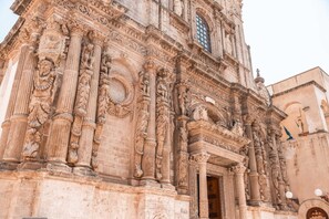 A historic building with intricate carvings, large columns, and a prominent arched doorway. - Cava Li Santi Residence - Monolocale 2 Int 12 (Santa Caterina)