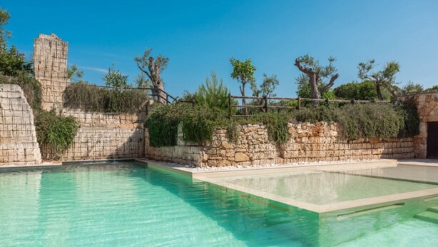 A clear swimming pool with stone walls and vegetation. - Cava Li Santi Residence - Monolocale 2 Int 10 (Santa Caterina)
