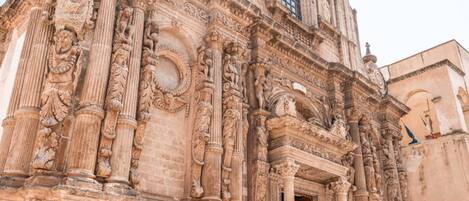 A historic building with intricate carvings, large columns, and a prominent arched doorway.