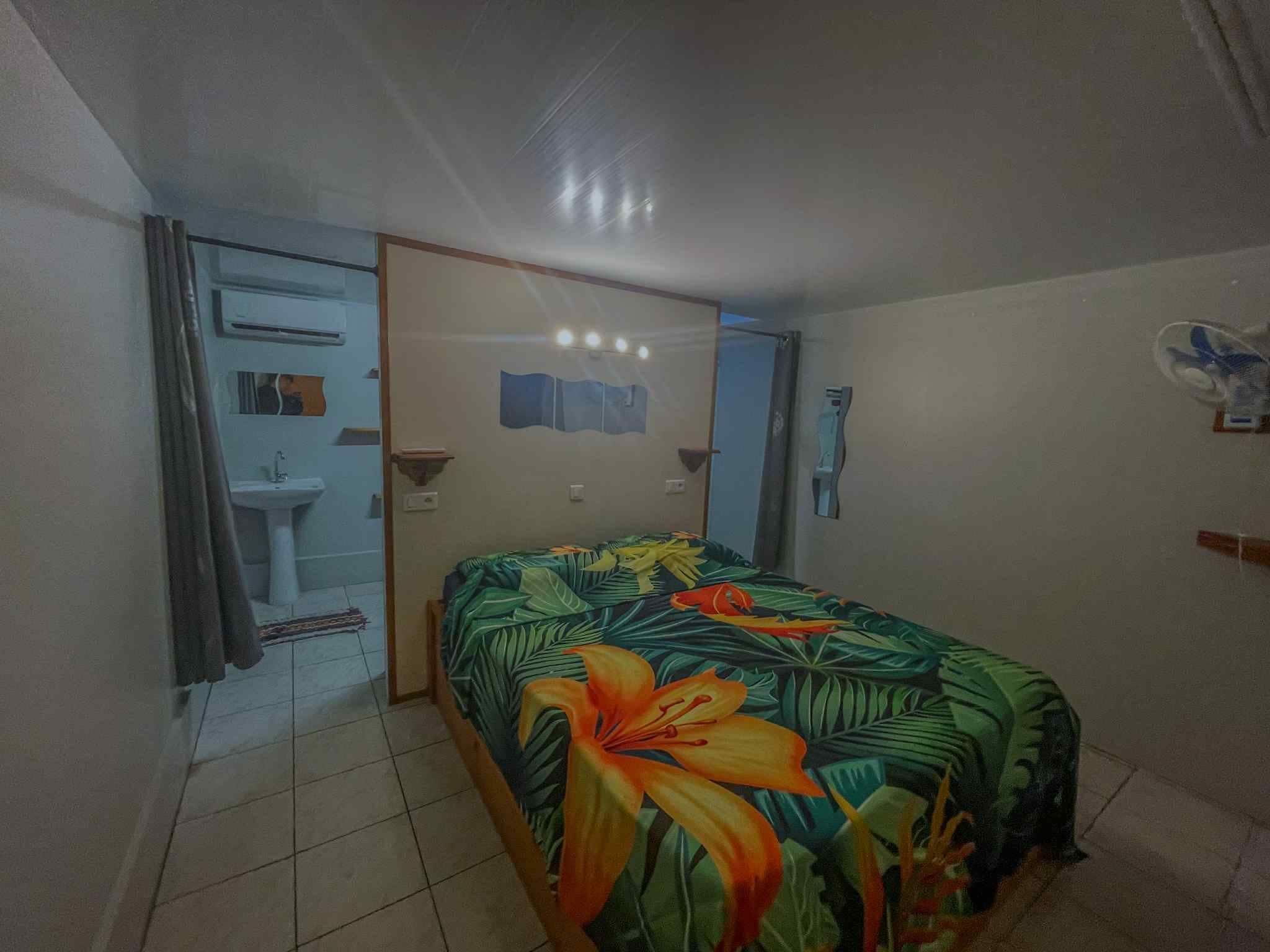 A bedroom with a bed, a bathroom, and a door.