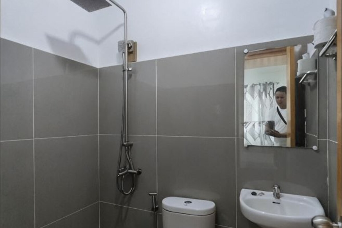 A bathroom with a shower, toilet, and sink.