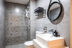 A bathroom with a patterned tile wall, a toilet, a sink with a mirror, and a towel rack. - Instagrammable Arte Mont Kiara 2 Rooms (Kuala Lumpur)