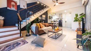 A modern living room with a staircase, a sofa, a coffee table, and a dining area. - Instagrammable Arte Mont Kiara 2 Rooms (Kuala Lumpur)