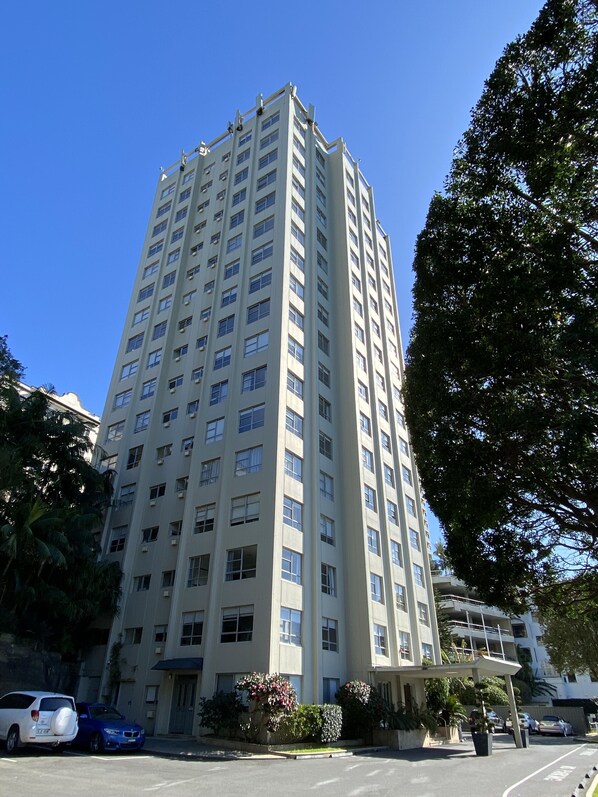 Un edificio alto de varios pisos con numerosas ventanas y una fachada plana.