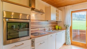 A modern kitchen with a built-in oven, stainless steel cabinets, and a wooden countertop.