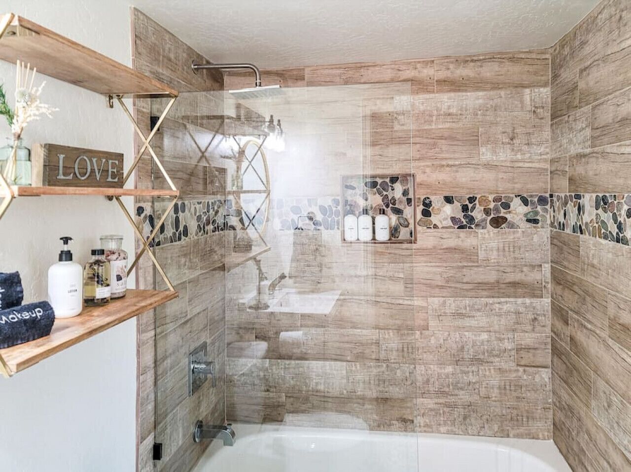 A bathroom with a wooden vanity, a shower area, and a bathtub.