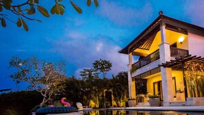 A two-story building with a balcony, surrounded by a pool and tropical plants. - Villa Lumi with Private Pool - 3BR (Pecatu)