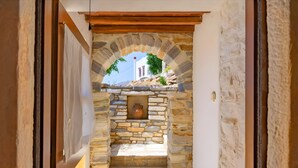 A stone archway leading to a courtyard with a tiled floor and a potted plant. - Zeus House Country Home with Mountain View, 2 Private Terraces & Wi-Fi (Naxos)
