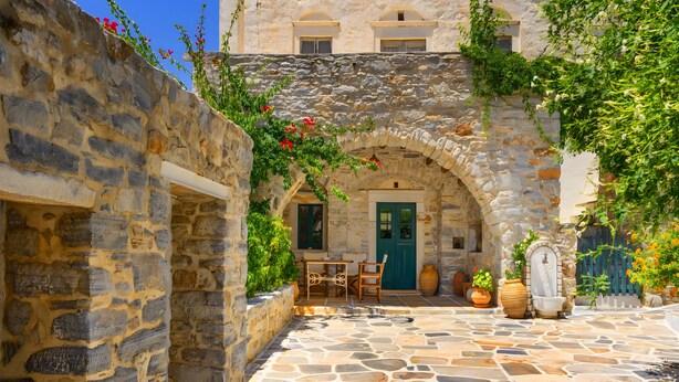 A stone courtyard with a table and chairs, a door, and potted plants. - Zeus House Country Home with Mountain View, 2 Private Terraces & Wi-Fi (Naxos)