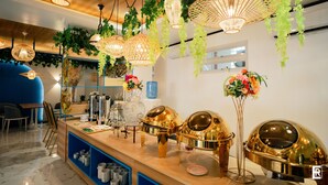 A buffet area with hanging wicker chandeliers, a wooden counter, and a blue seating area.
