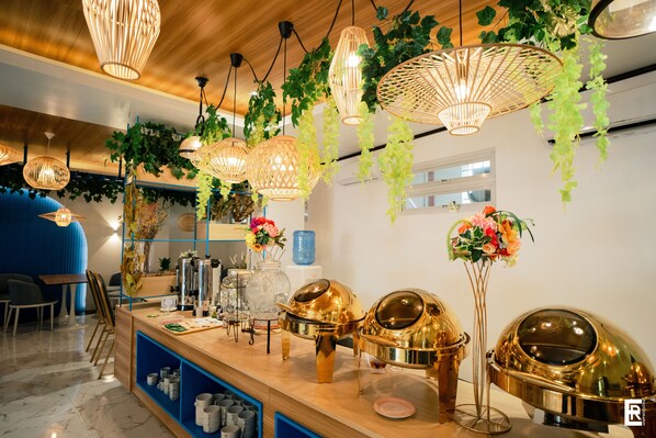 A buffet area with hanging wicker chandeliers, a wooden counter, and a blue seating area.