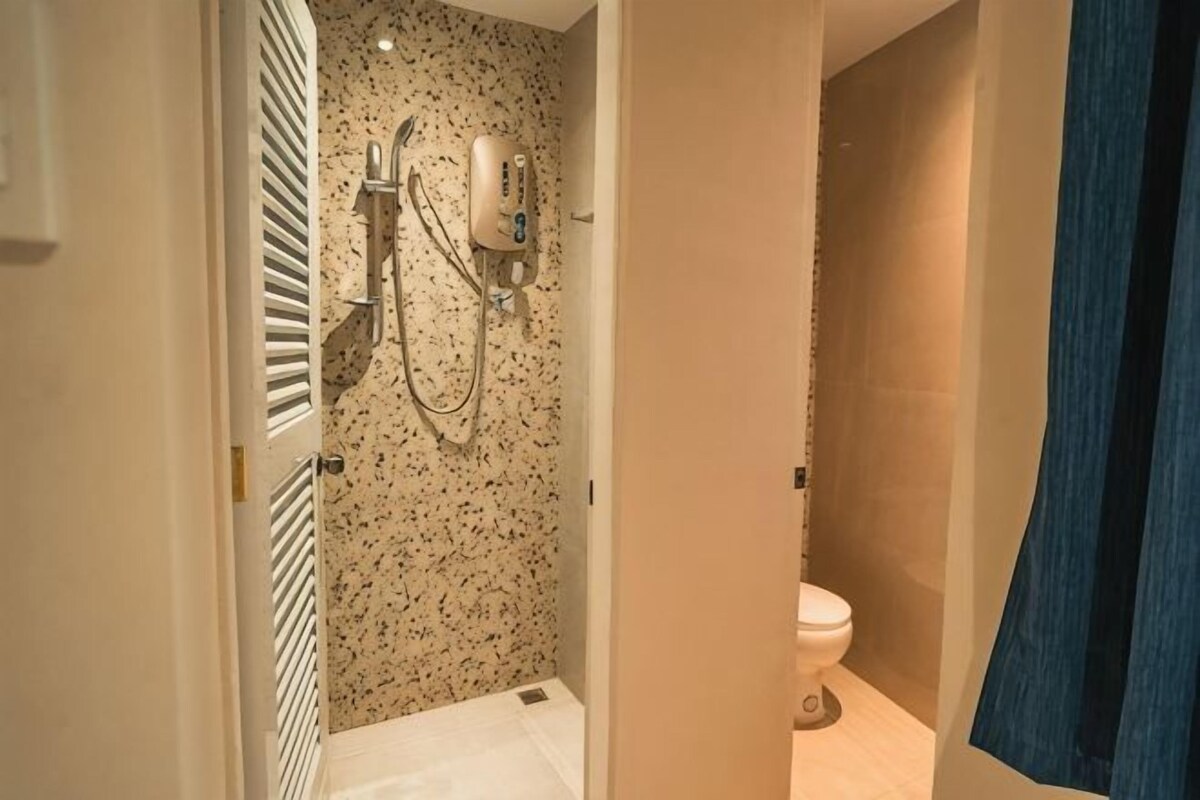 A bathroom with a shower, toilet, and towel rack.
