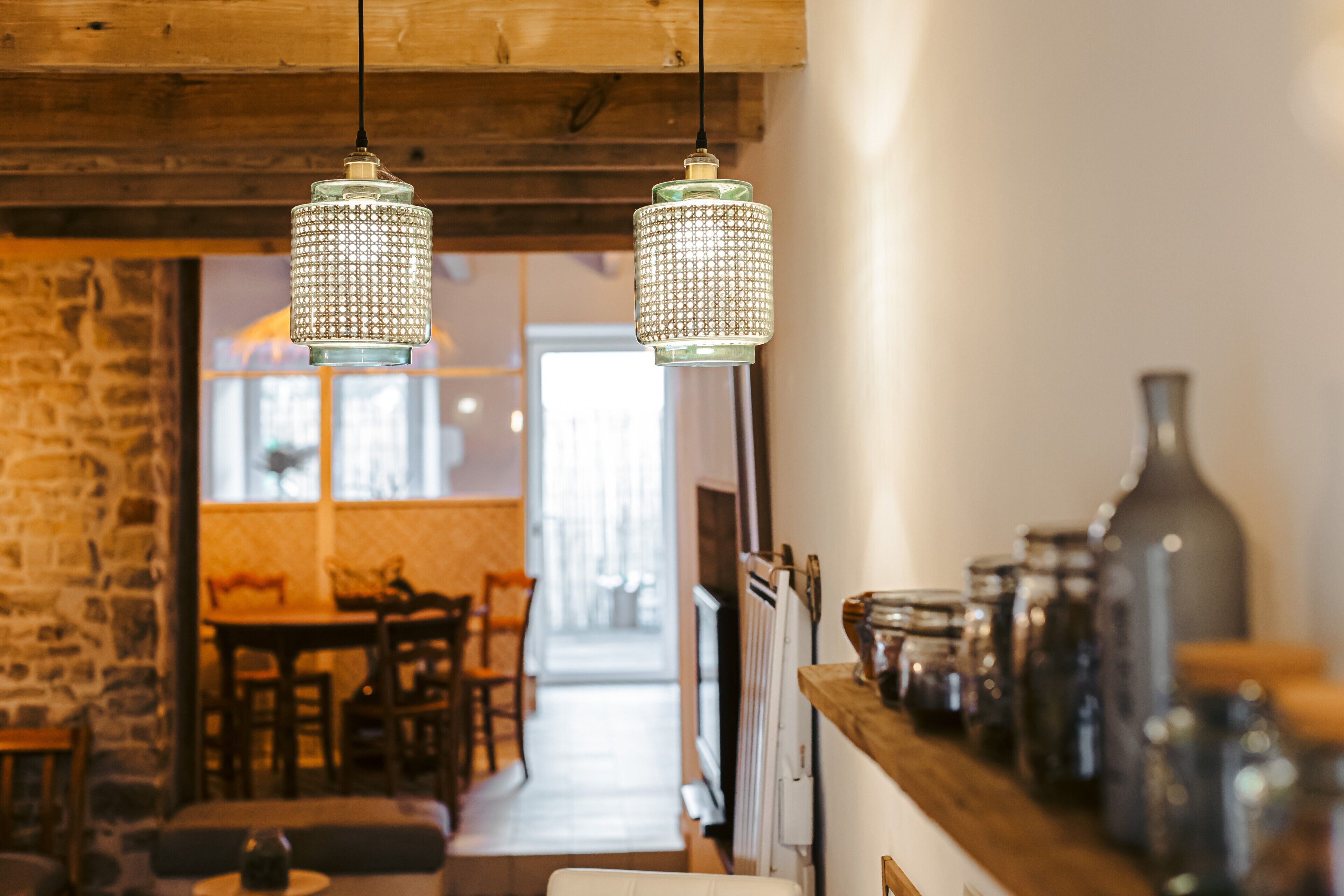 Un ambiente accogliente con lampade a sospensione, una parete in pietra e un soffitto in legno.
