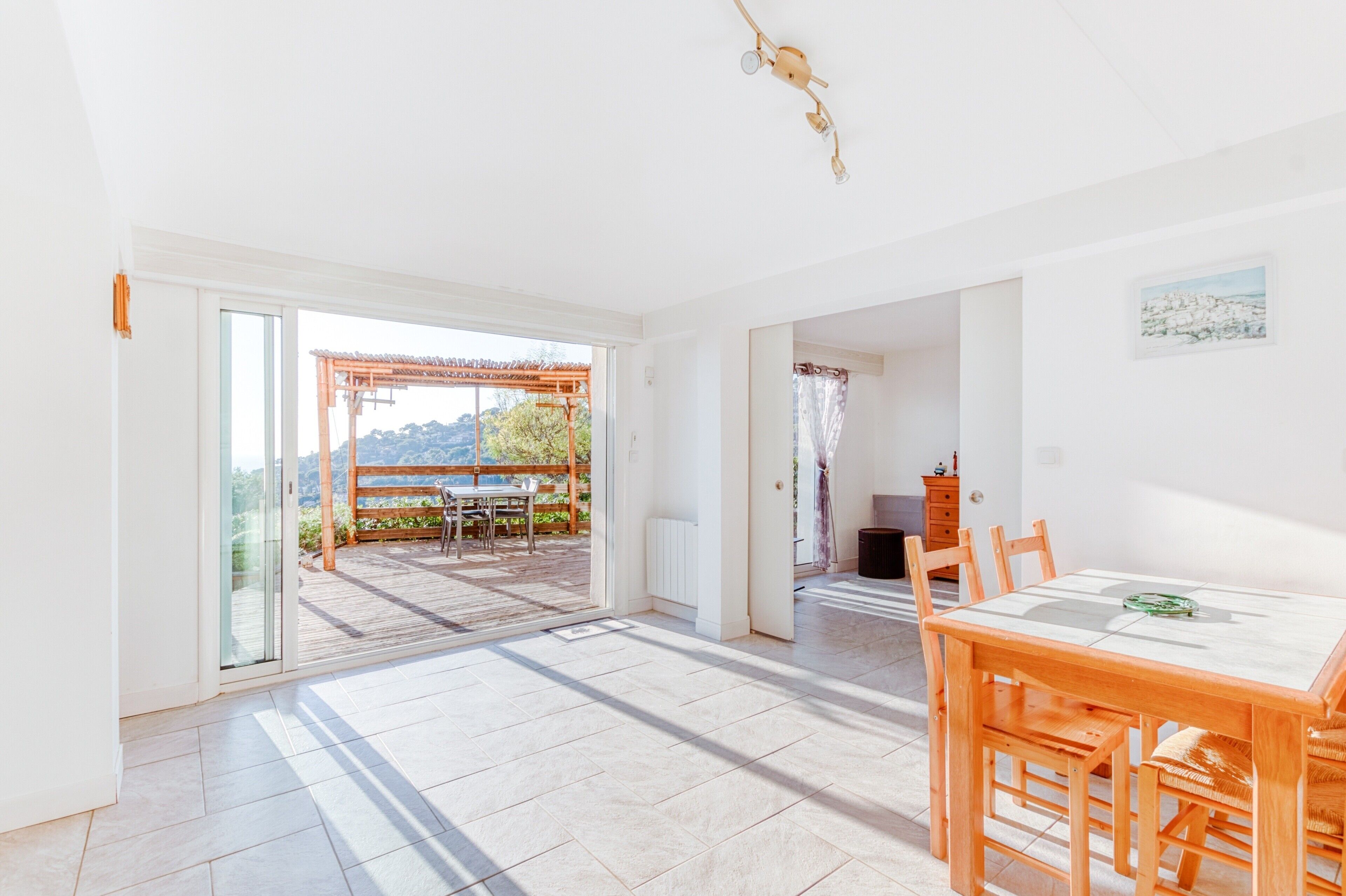 A spacious room with a large sliding glass door leading to an outdoor patio area.