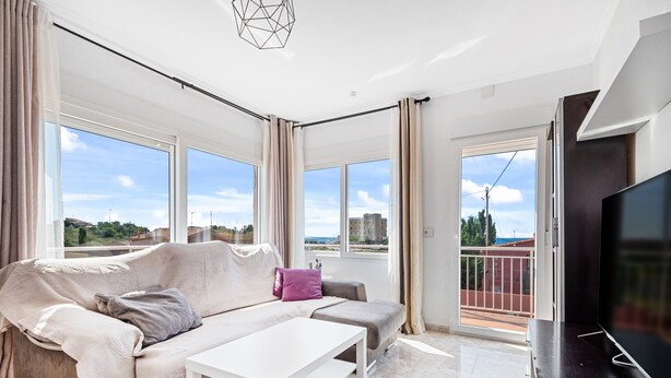 A modern living room with a sofa, a coffee table, and a TV.