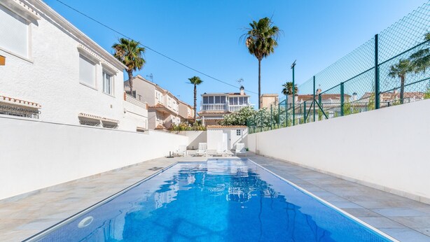A swimming pool with clear blue water, surrounded by white walls and a fence. - Apartment 'Las Calas Deluxe B' with Shared Pool, Private Terrace and Wi-Fi (Torrevieja)