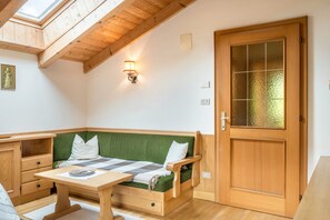 A cozy room with a wooden bench, a table, and a door with frosted glass panels.
