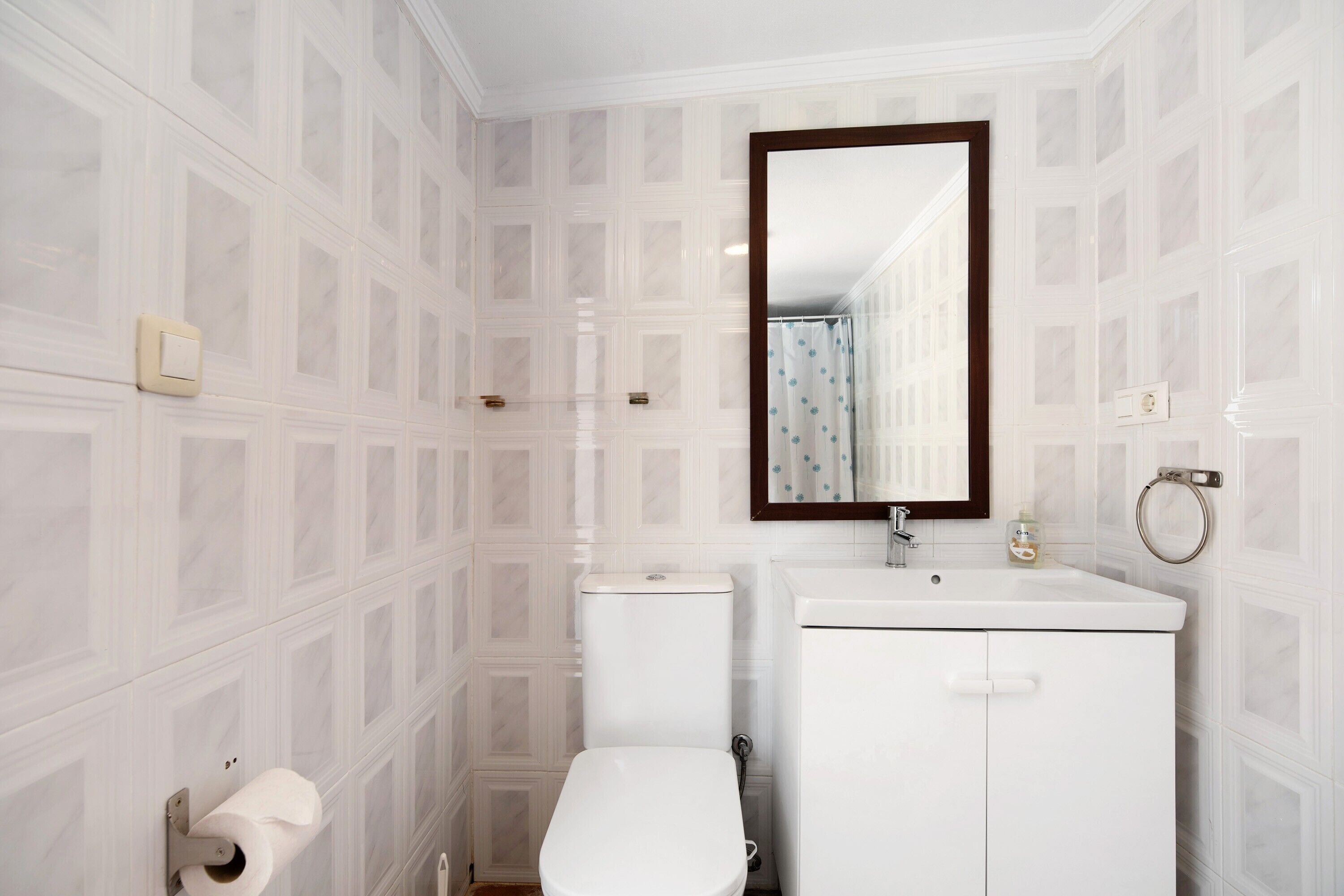 Une salle de bain avec des toilettes, un lavabo et un miroir.