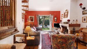 A living room with a sofa, chairs, a coffee table, a fireplace, and a television. - Villa 'Little Paradise 25 Min From Lisbon' with Private Pool, Private Terrace and Wi-Fi (Azeitão)