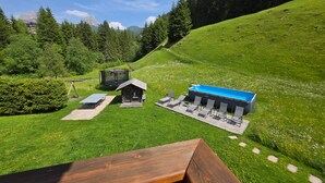 A wooden bench, a small cabin, a trampoline, and a pool area in a green landscape with trees and mountains in the background. - Apartment "Piciulei Grant" with Mountain View, Garden, and Wi-Fi (Selva di val gardena)
