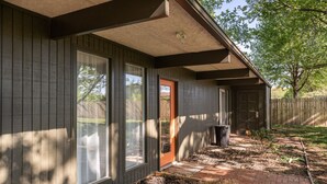 A house with a front porch, large windows, and a brick pathway leading to the door. - Retro Vibes | Mid-Century Gem in Springfield (Springfield)