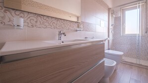Une salle de bain moderne avec un grand lavabo, un miroir et une douche.
