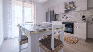 Une cuisine moderne avec une table à manger, des chaises et un réfrigérateur.