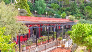 A building with a red roof, a balcony with railings, and potted plants. - Holiday Apartment 'Garden Cottage I Dammusi - Ulivo' with Mountain View, Shared Pool & Wi-Fi (Castelmola)