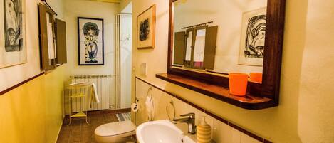 Een badkamer met een wastafel, hygiëneschuimer en spiegel.