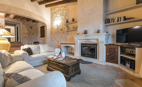 A living room with a fireplace, a sofa, a coffee table, and a television.