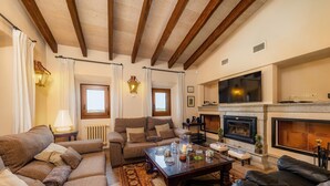 A living room with a fireplace, sofas, a coffee table, and a television. - Holiday Home 'Can Corem De Son Moix' with Mountain Views, Wi-Fi and Air Conditioning (Manacor)