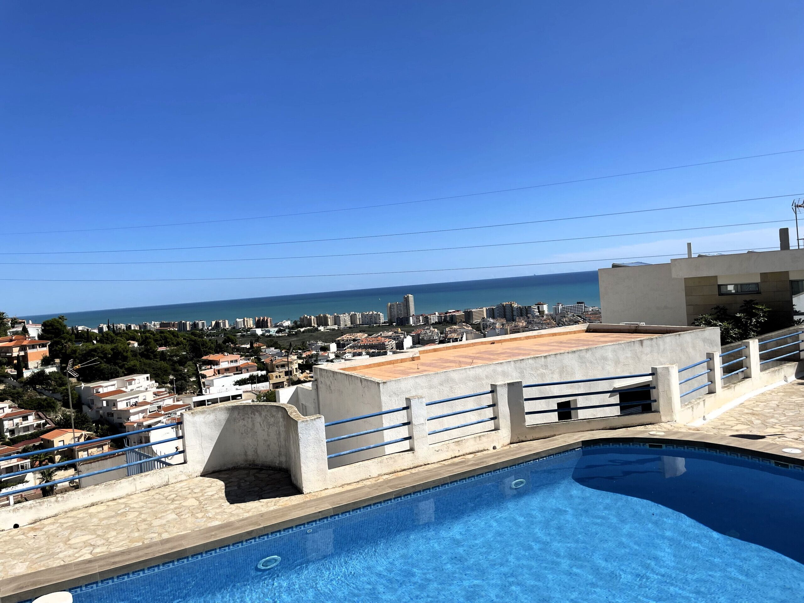 Ein Pool auf dem Dach mit Blick auf die Stadt und das Meer.