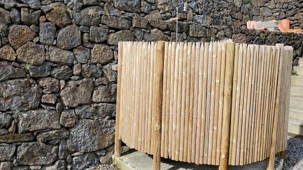 Un muro de piedra con una cerca de madera.
