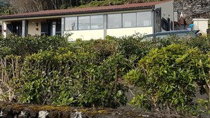 Un edificio con techo plano, ventanas amplias y pared de piedra.