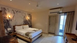 A modern bedroom with a large bed, a wooden nightstand, a desk, and a wall-mounted TV. - Ariena by ABA Hotels (Morjim)