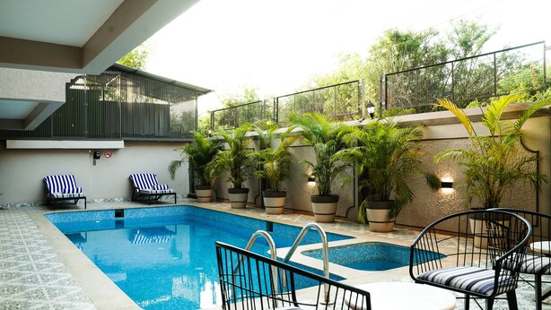 A swimming pool with lounge chairs and potted plants. - Ariena by ABA Hotels (Morjim)