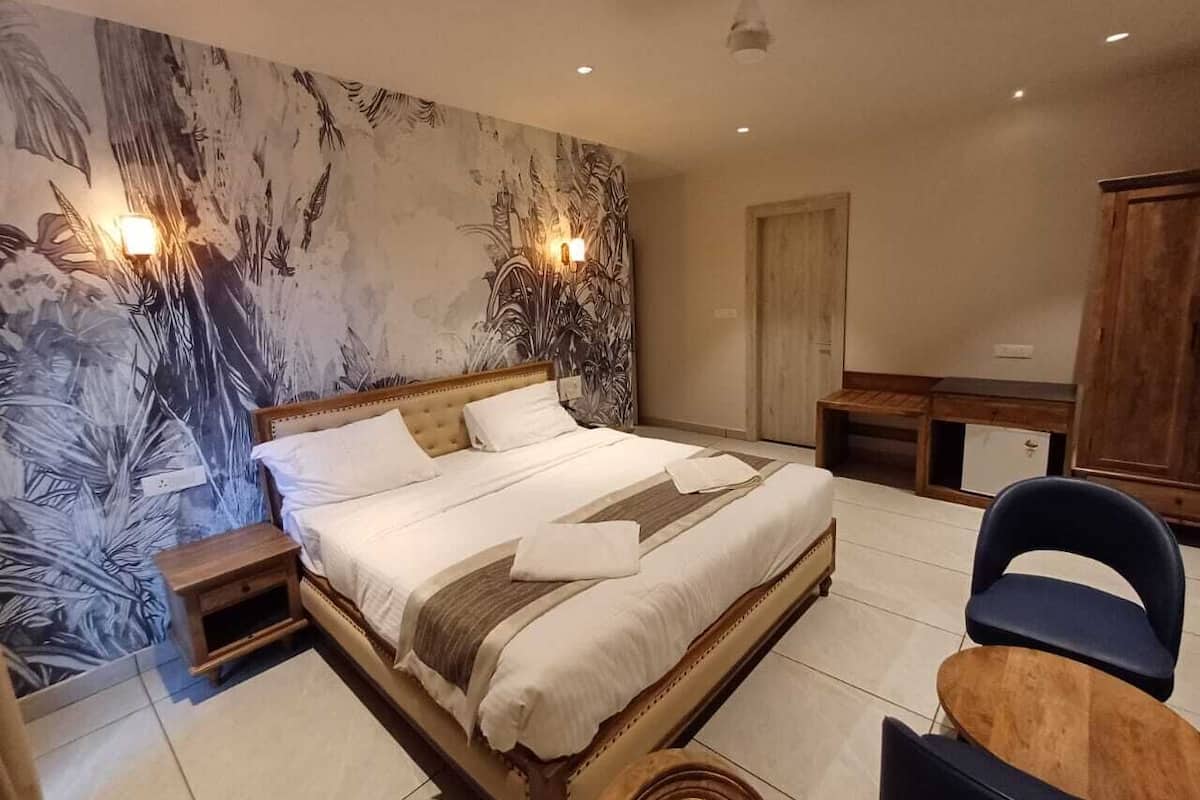 A bedroom with a bed, bedside tables, a chair, and a desk.