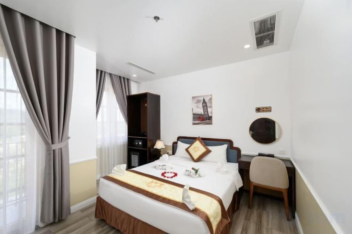 Une chambre d’hôtel avec un lit, un bureau et une chaise.
