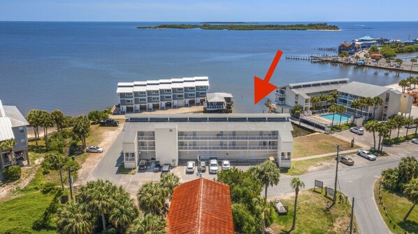 A hotel with a large building, a swimming pool, and a view of the ocean. - Gulf front condo with sunset views (Cedar Key)