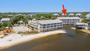 A coastal hotel with multiple buildings, a beach, and a water body. - Gulf front condo with sunset views (Cedar Key)