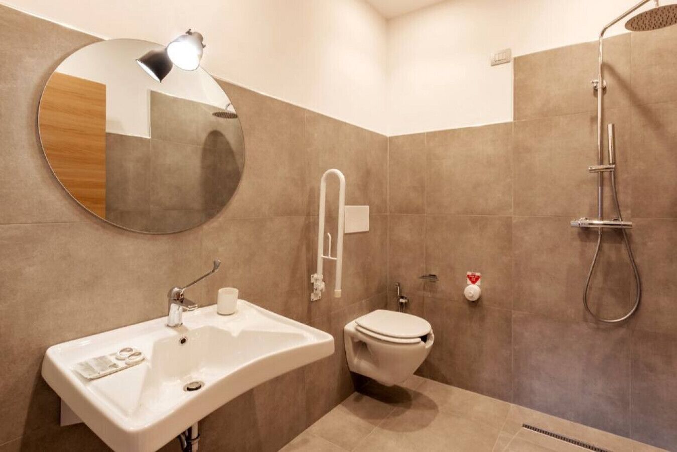 Une salle de bain moderne équipée d’un lavabo, de toilettes et d’une douche.