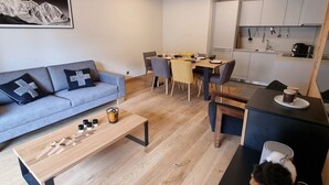 A modern living room with a sofa, coffee table, and dining area.